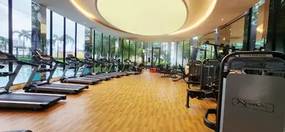 a gym with a row of treadmills and ellipticals at TRION KL Premier Residence in Kuala Lumpur