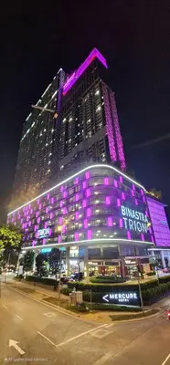 a large building with purple lights on it at night at TRION KL Premier Residence in Kuala Lumpur