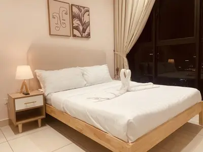 a bedroom with a bed with white sheets and a window at Comfy 1BR klcc view imperial suite B47 09 Trion KL in Kuala Lumpur