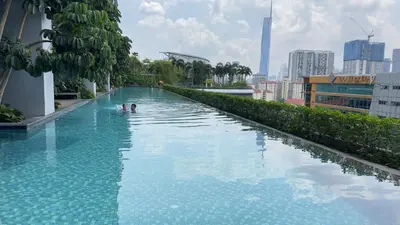 two people swimming in a swimming pool in a city at Comfy 1BR klcc view imperial suite B47 09 Trion KL in Kuala Lumpur