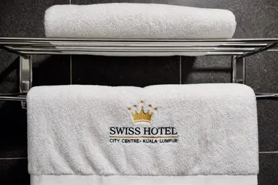 a rack of towels with a swiss hotel sign on them at Swiss Hotel at City Centre in Kuala Lumpur