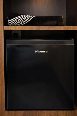 a black microwave with a baseball bat on a shelf at Swiss Hotel at City Centre in Kuala Lumpur