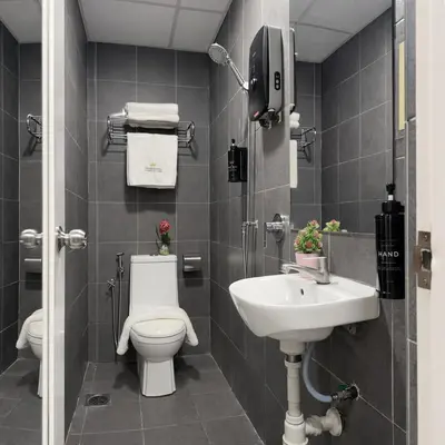 a bathroom with a toilet and a sink at Swiss Hotel at City Centre in Kuala Lumpur