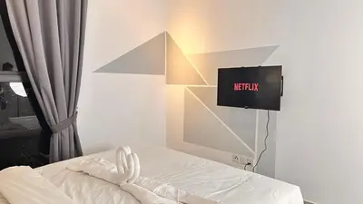 a bedroom with a bed with a tv on the wall at Couple Private studio B22 11 Trion KL in Kuala Lumpur