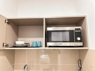 a microwave sitting on a shelf in a kitchen at Couple Studio Suite A16 07 Trion KL in Kuala Lumpur
