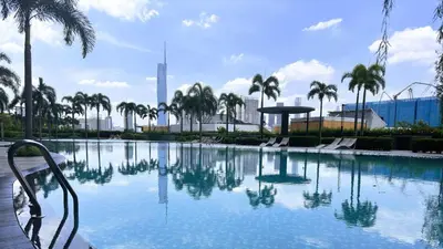 a large swimming pool with palm trees and a building at Couple Studio Suite A16 07 Trion KL in Kuala Lumpur