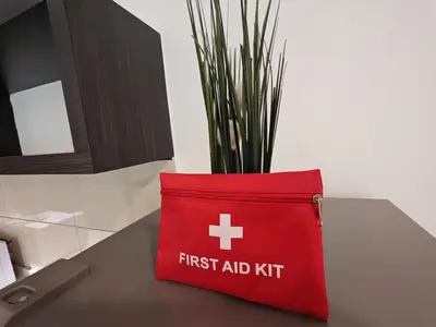 a red first aid kit sitting on a table with a plant at O 3 Room 200mbps wifi near Mrt Lrt HKL PWTC KLCC in Kuala Lumpur