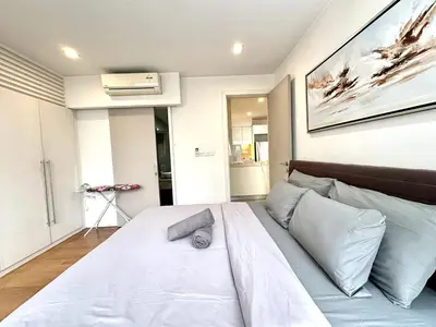 a bedroom with a large white bed with blue pillows at Bintang Fairlane Residence, KLCC & City View with Bathtub - 2B1R in Kuala Lumpur