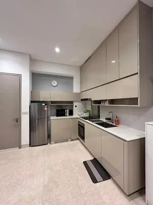 a large kitchen with stainless steel appliances and white cabinets at Lucentia Residences By CasaLuxe in Kuala Lumpur