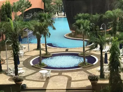 a large pool with palm trees in a building at Times Apartment at Times Square in Kuala Lumpur