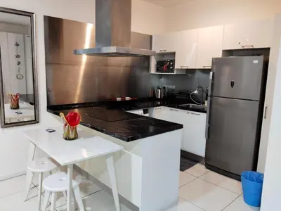 a kitchen with white cabinets and a stainless steel refrigerator at Condo in Jalan Ampang- near KLCC IJN Gleneagles HKL TRX in Kuala Lumpur