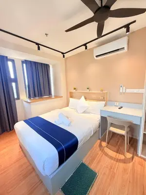 a bedroom with a bed with a desk and a ceiling fan at The Sentral Nook KL Sentral By Riveria city in Kuala Lumpur