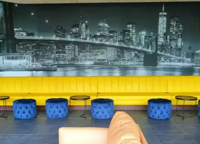 a waiting room with blue stools and a yellow bench at Neu Suites in Kuala Lumpur