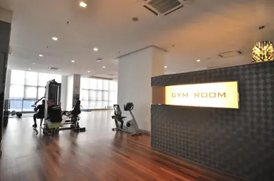 a gym with a gym room with people sitting in chairs at Amazing KLCC View @ Regalia Residence in Kuala Lumpur