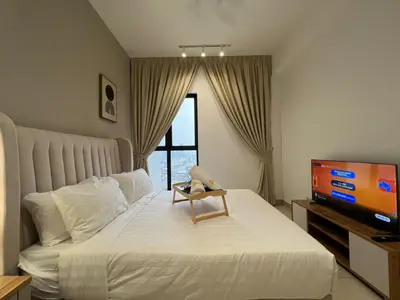 a bedroom with a bed with a tv and a teddy bear on it at Trion KL By AlwaysHome in Kuala Lumpur