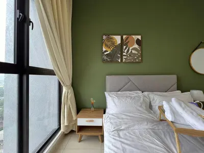 a bedroom with a bed and a green wall at Trion KL By AlwaysHome in Kuala Lumpur