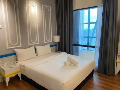 a bedroom with a large white bed with a window at Stylish 2 bedroom duplex bedroom city center in Kuala Lumpur