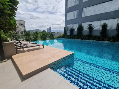 a large swimming pool with a wooden bench next to a building at Compact Studio Near Gleneagles KLCC in Kuala Lumpur