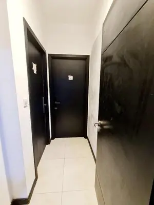 a hallway with two black doors and a tile floor at Compact Studio Near Gleneagles KLCC in Kuala Lumpur