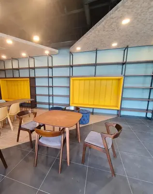 a room with tables and chairs and yellow dividers at Neu Suites Tiny Queen Bed Studio 10 mins to KLCC in Kuala Lumpur