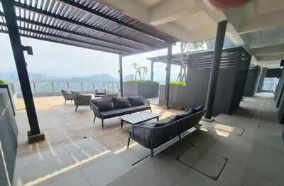a patio with couches and tables and a view of the ocean at Neu Suites Tiny Queen Bed Studio 10 mins to KLCC in Kuala Lumpur