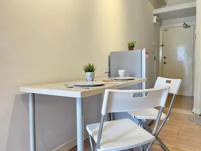a kitchen with a table with chairs and a refrigerator at Holiday Place Residence Kuala Lumpur in Kuala Lumpur