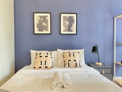 a bedroom with a bed with two pictures on the wall at Holiday Place Residence Kuala Lumpur in Kuala Lumpur