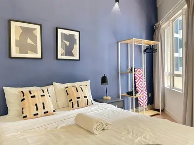 a bedroom with a large bed with blue walls at Holiday Place Residence Kuala Lumpur in Kuala Lumpur