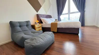 a bedroom with a bed and a chair and a couch at UNA Residensi Jln Peel Fully Air Con Homestay in Kuala Lumpur