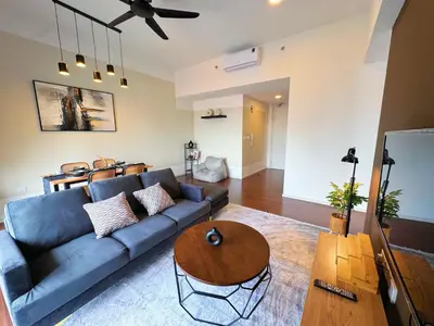 a living room with a blue couch and a table at UNA Residensi Jln Peel Fully Air Con Homestay in Kuala Lumpur