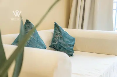 two blue pillows sitting on a white couch at 6 pax Modern 3BR Stay in Sentul near KL City in Kuala Lumpur