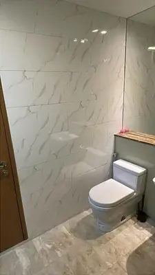 a bathroom with a toilet and a white wall at Soho Suites KLCC by City Keys in Kuala Lumpur