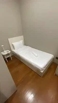 a white bed in a room with a side table at Soho Suites KLCC by City Keys in Kuala Lumpur