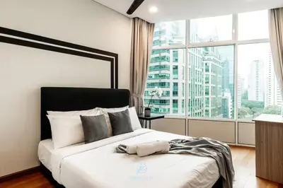a bedroom with a large bed with a large window at Skysuites Twin Tower Prime Location in Kuala Lumpur