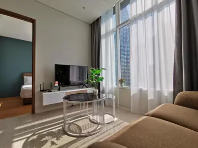 a living room with a table and a tv at Skysuites Twin Tower Prime Location in Kuala Lumpur