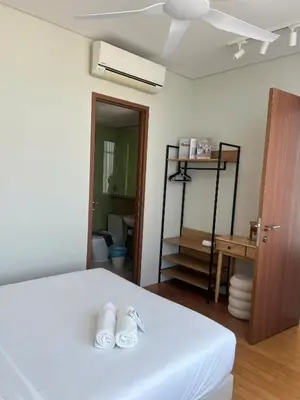 a bedroom with a white bed and a bathroom at Skysuites Twin Tower Prime Location in Kuala Lumpur