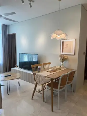 a dining room with a table and chairs and a tv at Skysuites Twin Tower Prime Location in Kuala Lumpur