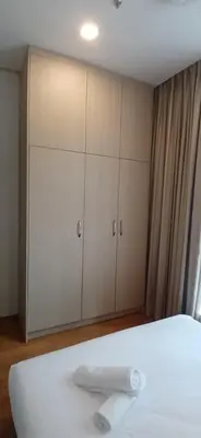 a bedroom with white cabinets and a white bed at SOHO Suites KLCC by noon in Kuala Lumpur