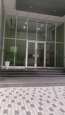 a large glass building with a potted plant in front of it at SOHO Suites KLCC by noon in Kuala Lumpur