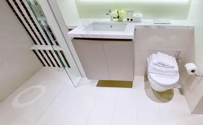 a white bathroom with a toilet and a sink at SOHO Suites KLCC by noon in Kuala Lumpur