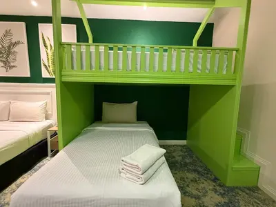 a green room with two bunk beds with towels at Asto Hotel Kuala Lumpur in Kuala Lumpur