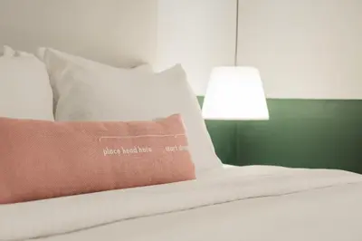 a bed with a pillow and a lamp on it at Swing & Pillows - Kentomen Hotel, Bamboo Hills in Kuala Lumpur