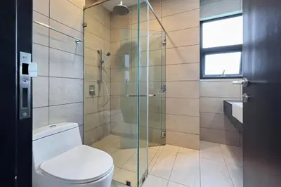 a bathroom with a toilet and a glass shower at Contemporary Apartment KL with 3 Bedrooms in Kuala Lumpur