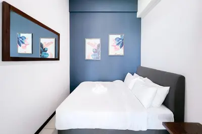 a bedroom with a white bed and a blue wall at Contemporary Apartment KL with 3 Bedrooms in Kuala Lumpur