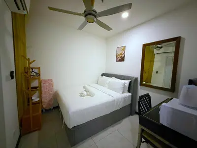 a bedroom with a bed with a ceiling fan and a mirror at Cozy unit By Rasbo Galaxy with LRT , Pool , KLCC in Kuala Lumpur