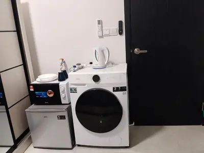 a washing machine sitting next to a microwave at Cozy unit By Rasbo Galaxy with LRT , Pool , KLCC in Kuala Lumpur