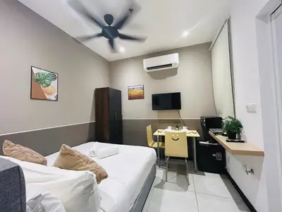 a room with a bed and a desk and a ceiling fan at Cozy unit By Rasbo Galaxy with LRT , Pool , KLCC in Kuala Lumpur