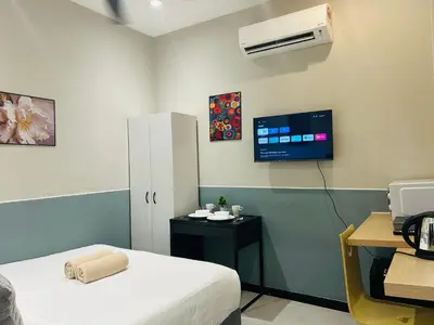 a room with a bed and a tv on the wall at Cozy unit By Rasbo Galaxy with LRT , Pool , KLCC in Kuala Lumpur