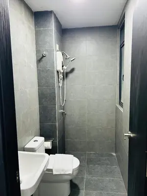 a bathroom with a white toilet and a shower at Cozy unit By Rasbo Galaxy with LRT , Pool , KLCC in Kuala Lumpur