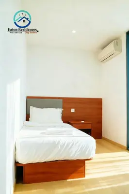 a bedroom with a large bed with a wooden headboard at Eaton Residence City Suites in Kuala Lumpur